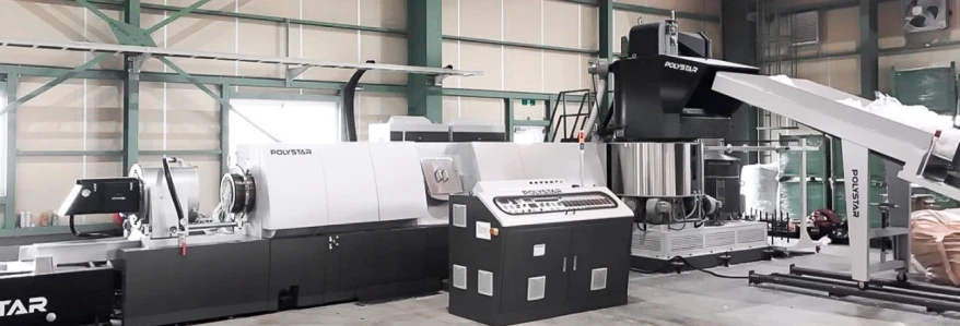 A large POLYSTAR industrial machine used for plastic recycling and processing in a factory.