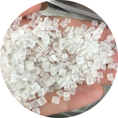 A hand holing clear plastic pellets, used as raw materials in plastic manufacturing.